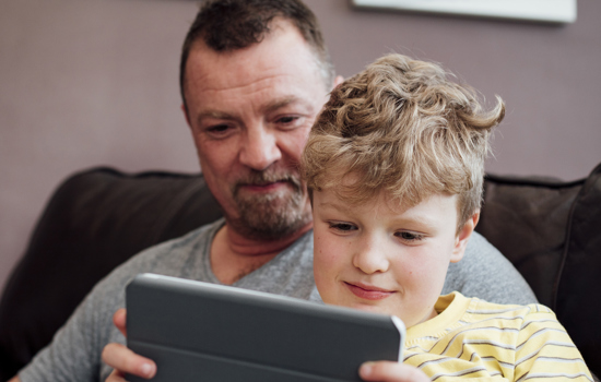 White father and son using ipad