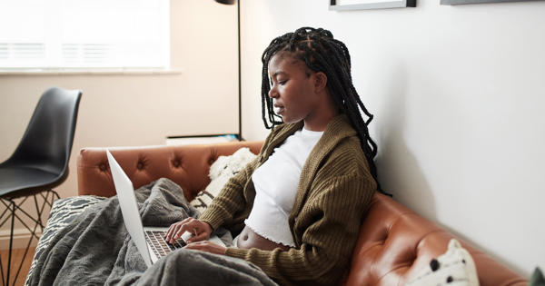 Black women on sofa using laptop