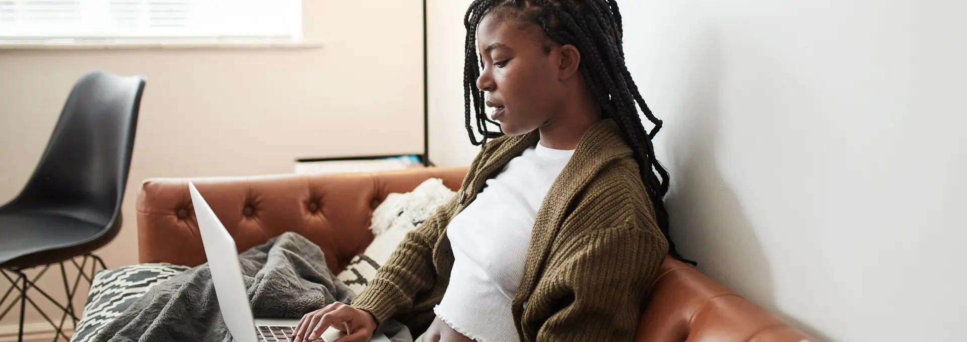 Black women on sofa using laptop