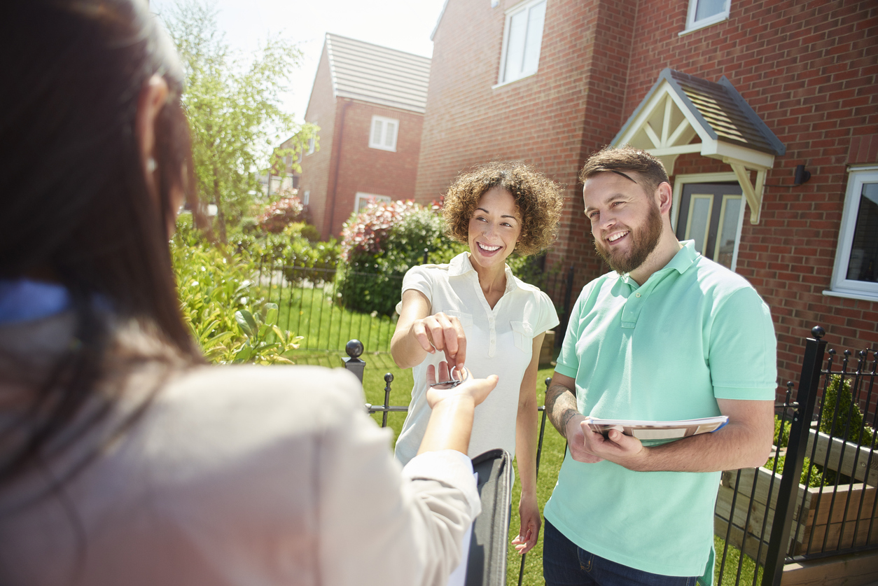 Couple accepting key to their new home - stock