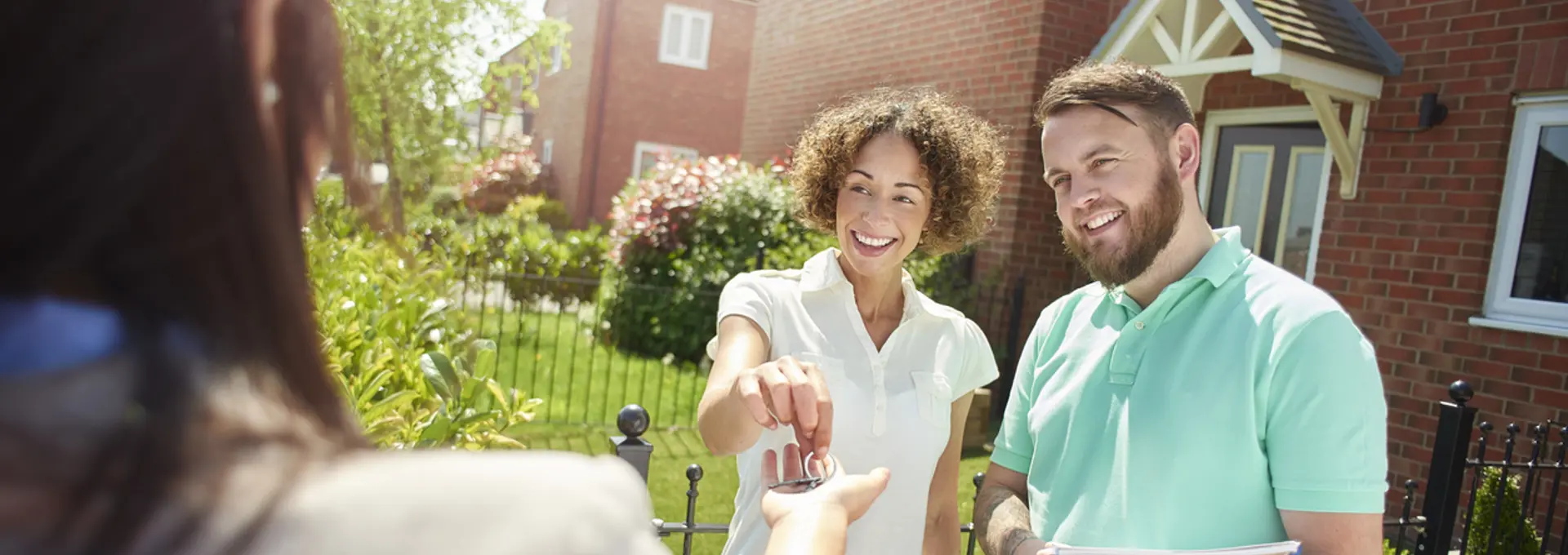 Couple accepting key to their new home - stock