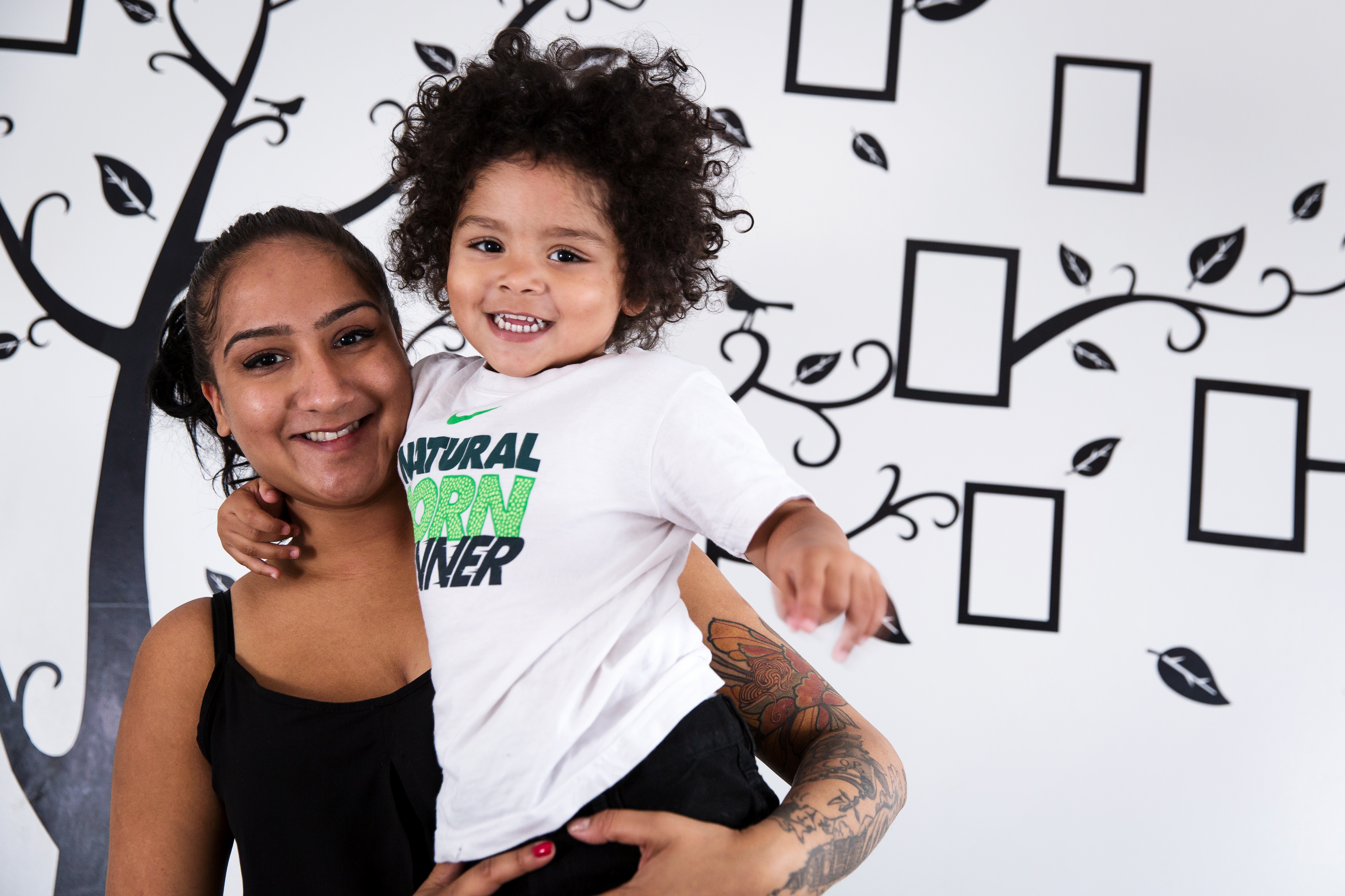 Black mother holding her son smiling