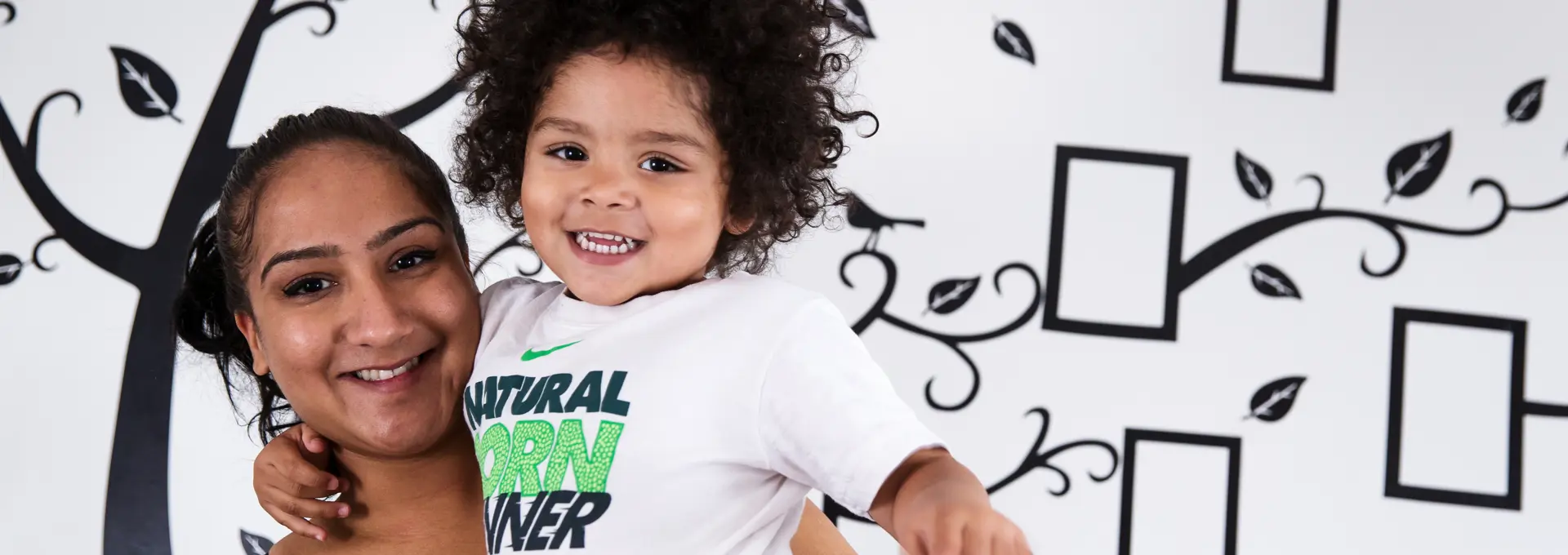 Black mother holding her son smiling