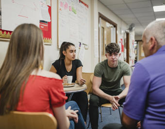 A group of 4 people, 2 women and 2 men sat down having a conversation 