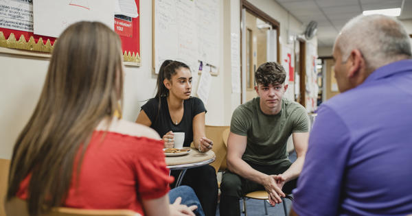 A group of 4 people, 2 women and 2 men sat down having a conversation 