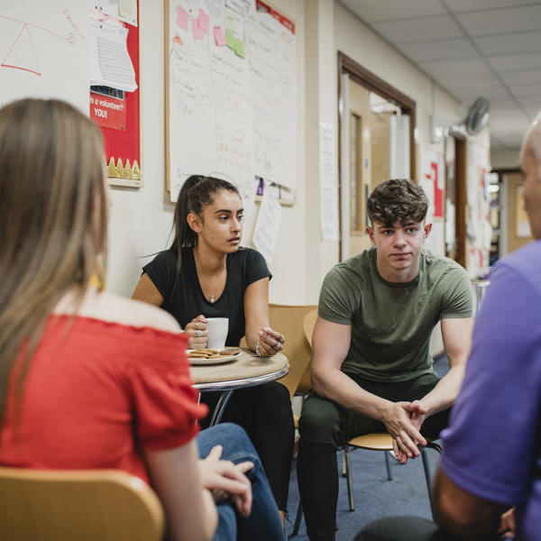 A group of 4 people, 2 women and 2 men sat down having a conversation 