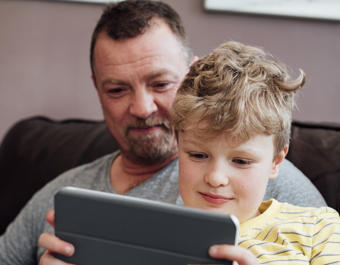 White father and son using ipad