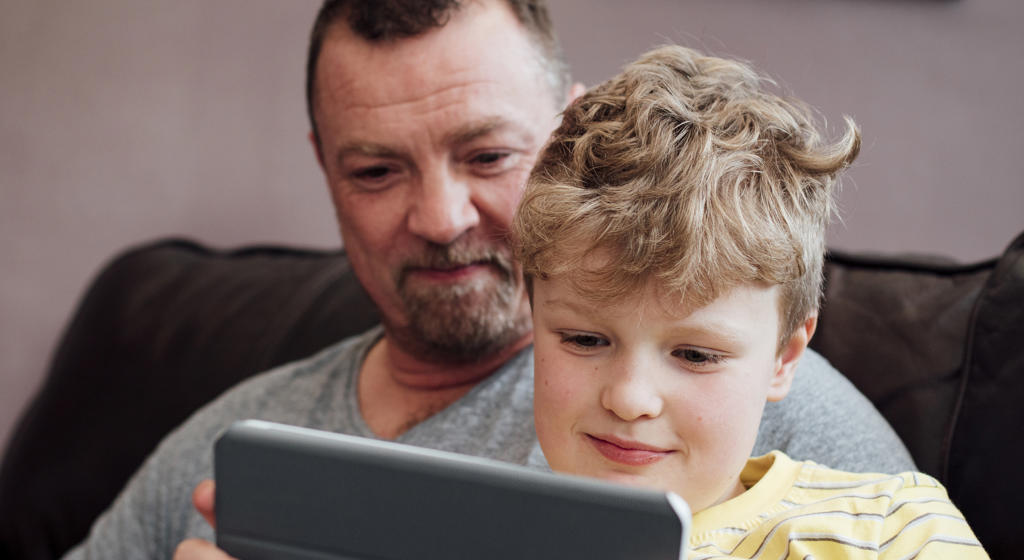 White father and son using ipad