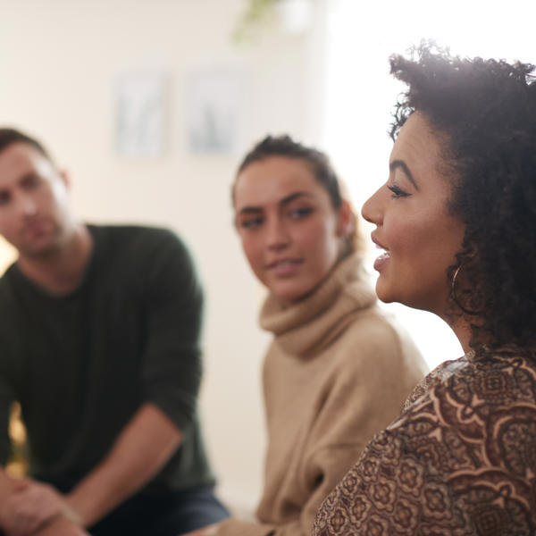 A group of men and women sat around in a circle at a meeting