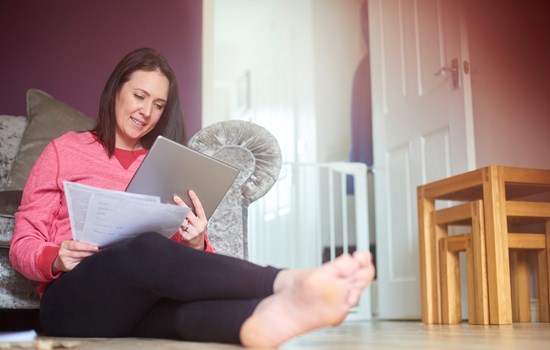Young white woman reading a document looking happy