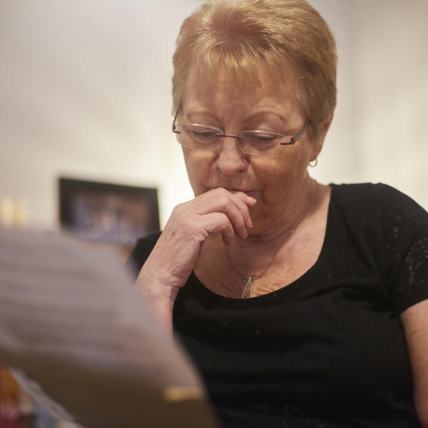 Older white woman reading a document looking pensive