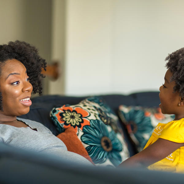 Black mother and toddler on their sofa