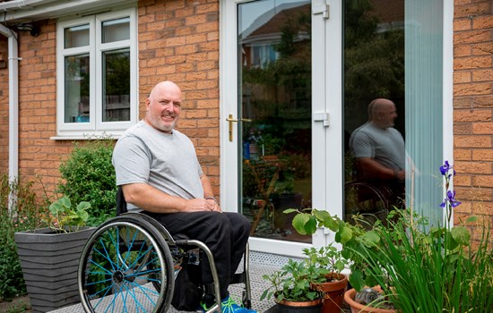Man in wheelchair outside his home