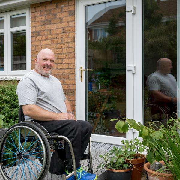 Man in wheelchair outside his home