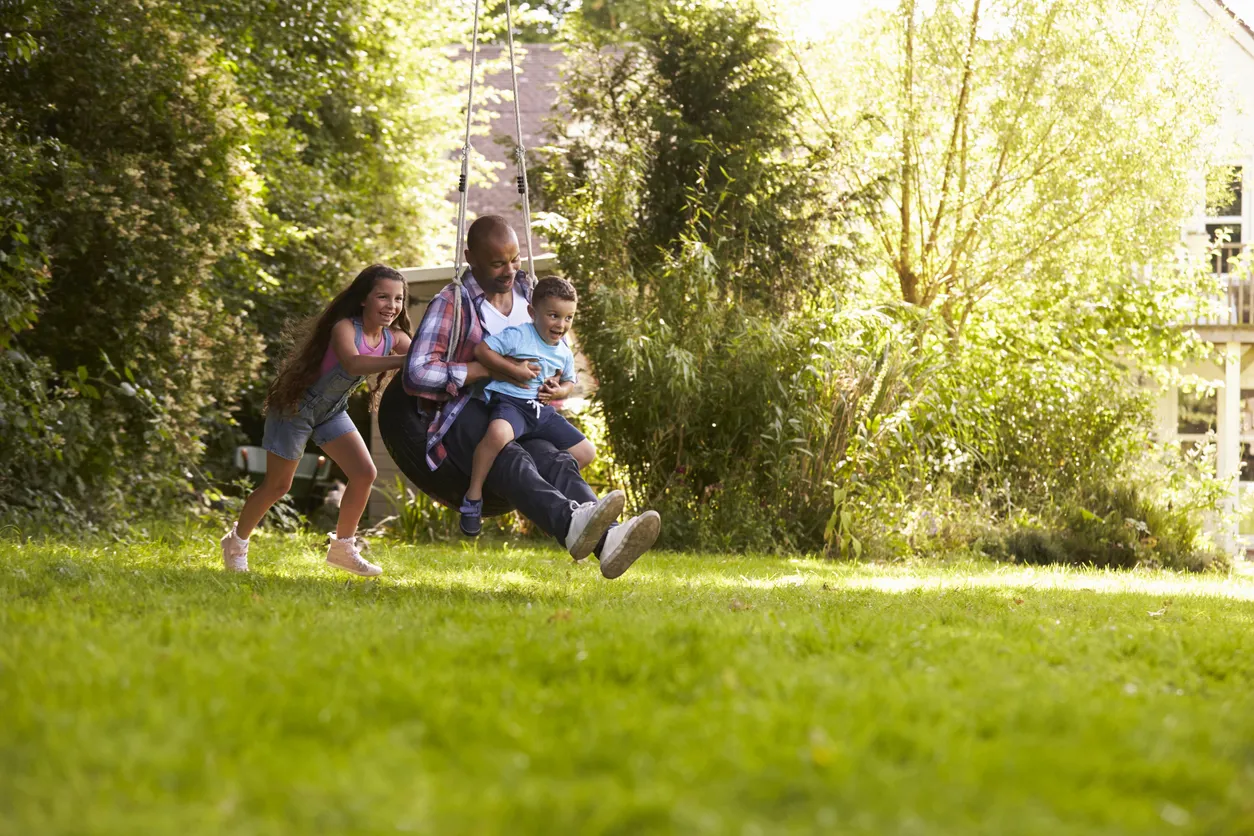Family on swing in the garden - stock