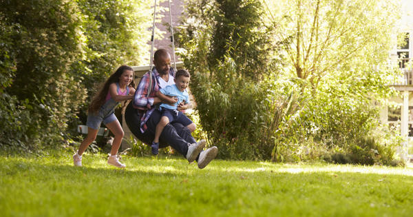 Family on swing in the garden - stock