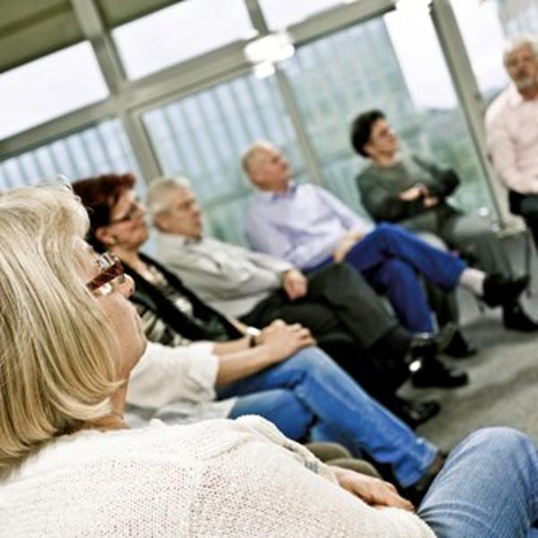 A group of people sat at a community meeting listening