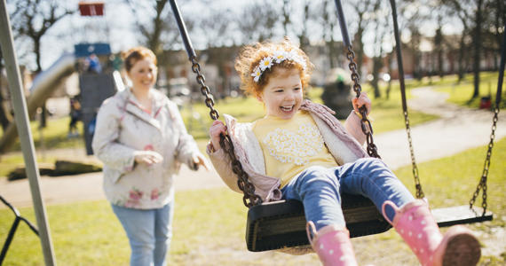 Mother pushing child on swing Mother pushing child on swing