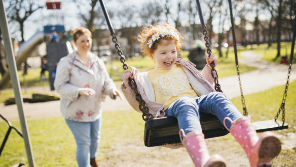 Mother pushing child on swing Mother pushing child on swing