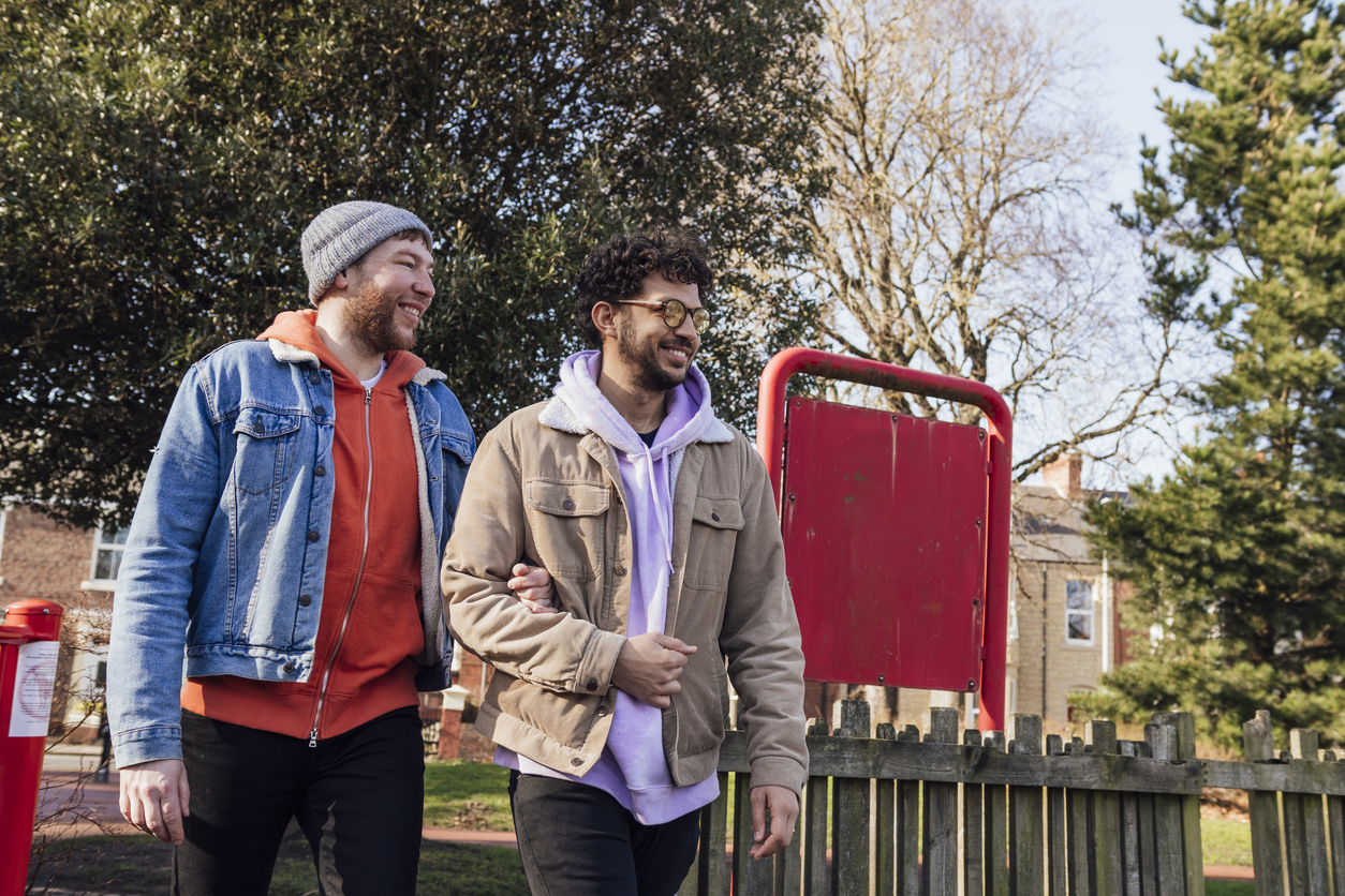 Gay couple walking through the park - stock