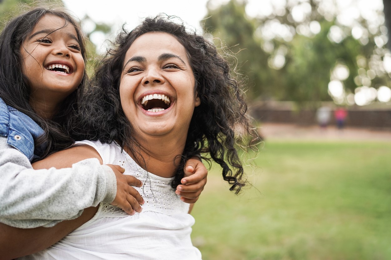 Mother giving daughter a piggyback - stock