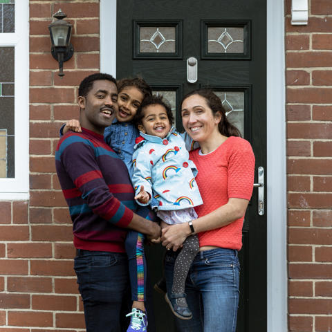 Family stood outside home - stock