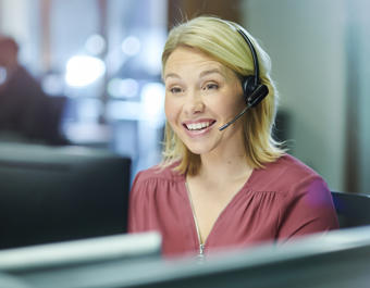 Female call centre worker wearing a headset and smiling