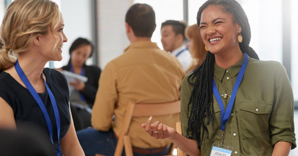 Two white women smiling during a business meeting in the office