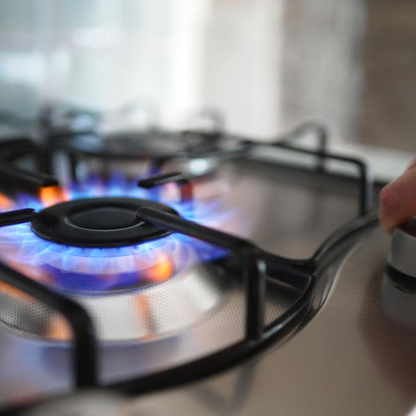 Woman turning on the gas burner on the stove