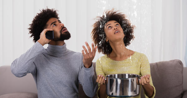 Woman Using Utensil For Collecting Water Leaking From Ceiling
