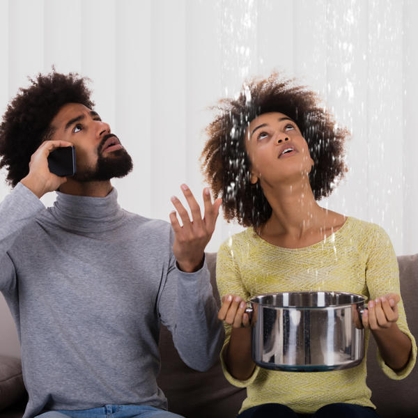 Woman Using Utensil For Collecting Water Leaking From Ceiling