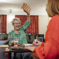 Older women wins at Bingo with her arm up celebrating