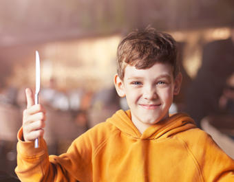 Boy with cutlery in his hands is ready to eat