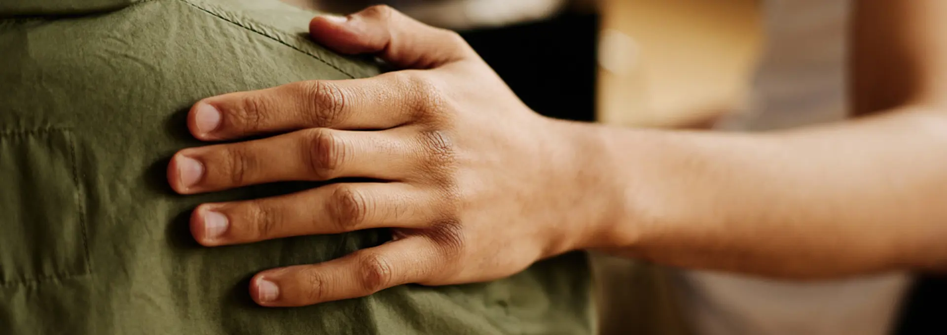 Hand of young supportive man consoling his friend with post traumatic syndrome