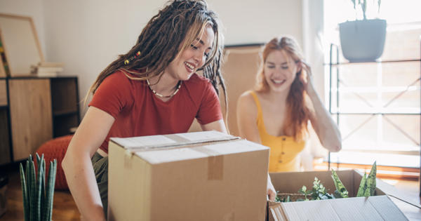 Two women packing boxes to move house