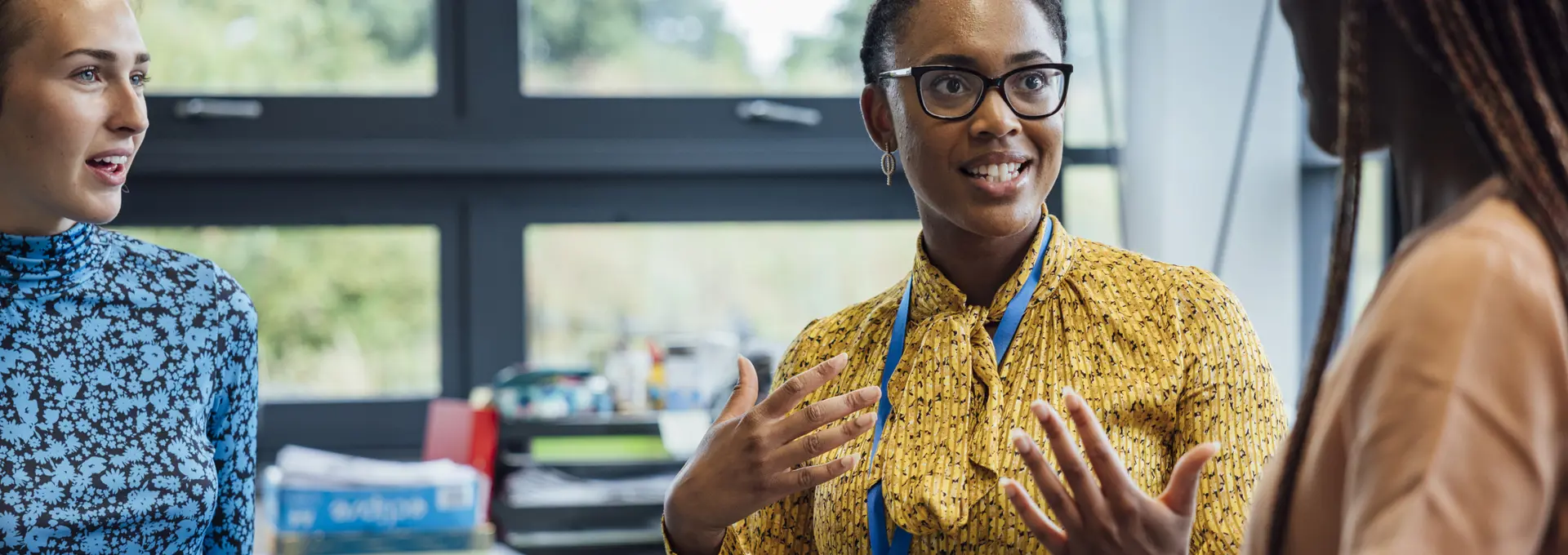 Black women chats with co-workers in the office