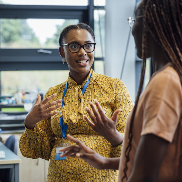 Black women chats with co-workers in the office