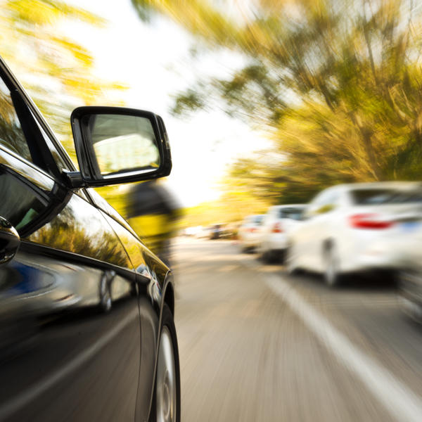 Black car driving down a busy street
