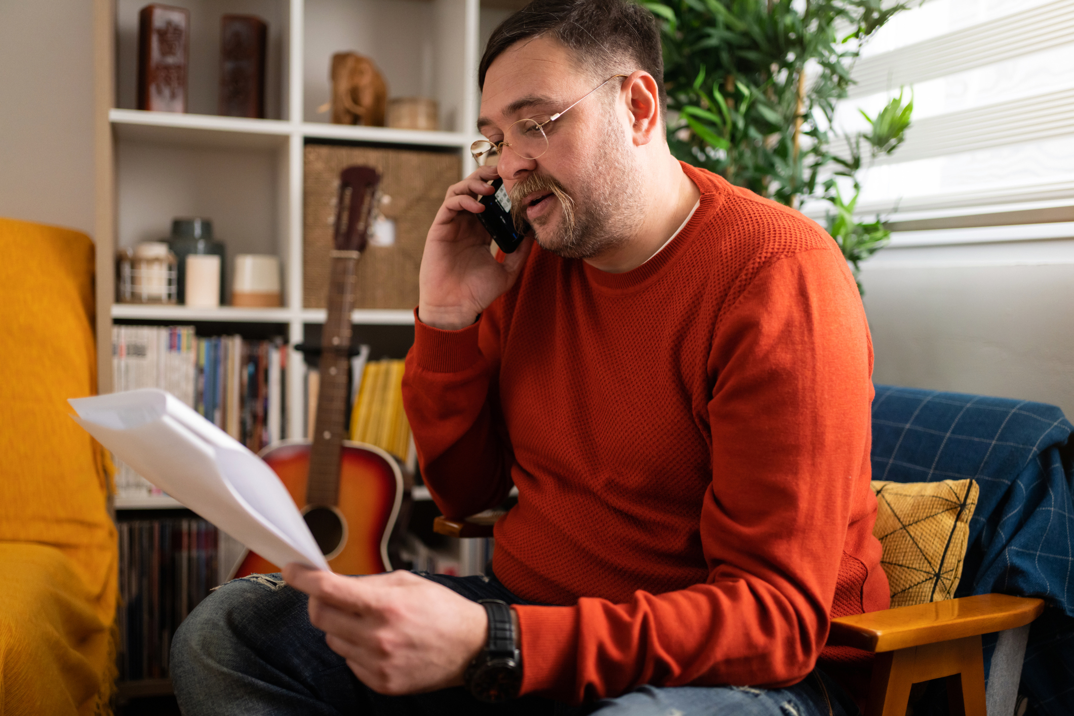 Man On Phone Looking Confused While Holding Paperwork