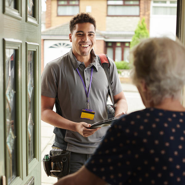 Workman at front door smiling at resident