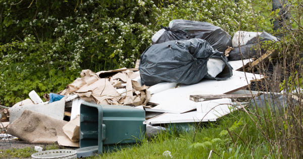 A large pile of abandoned rubbish on grass