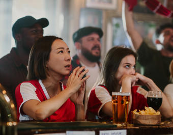 Diverse Group Of Sports Fans Intensely Watching A Game In A Pub, Experiencing Anxiety During A Competition