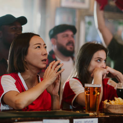 Diverse Group Of Sports Fans Intensely Watching A Game In A Pub, Experiencing Anxiety During A Competition