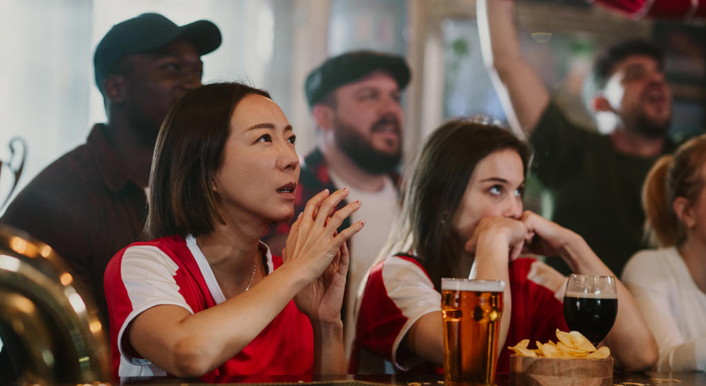 Diverse Group Of Sports Fans Intensely Watching A Game In A Pub, Experiencing Anxiety During A Competition