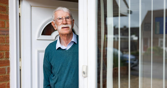 Old man stood at front door looking angry