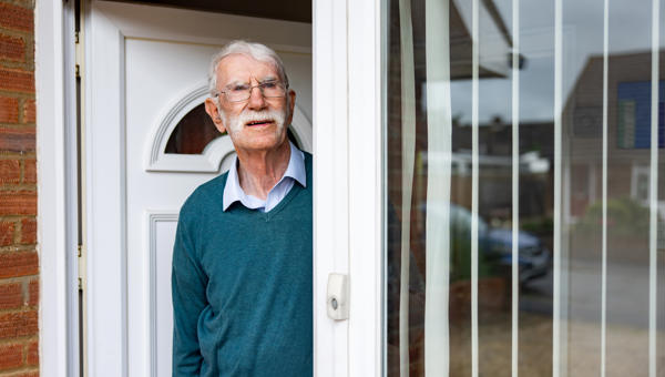 Old man stood at front door looking angry
