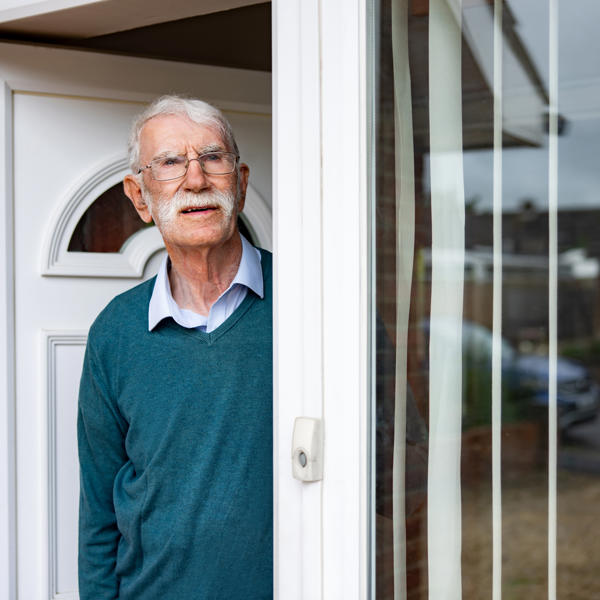 Old man stood at front door looking angry