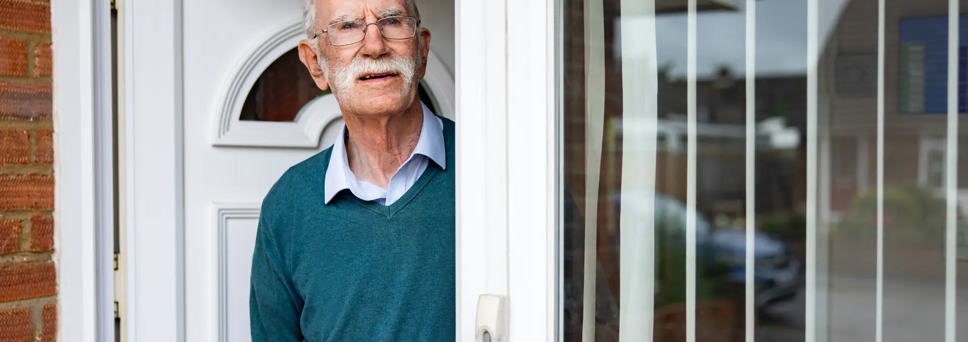 Old man stood at front door looking angry