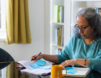 Asian women reading paperwork at home concentrating