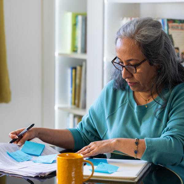 Asian women reading paperwork at home concentrating